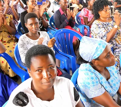 Women seated in a gathering, listening