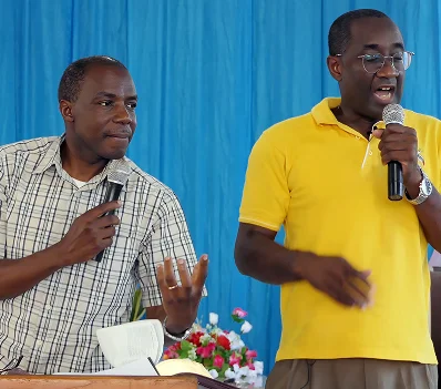 Two speakers greeting each other during a meeting